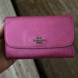 A metallic pink Coach wallet or clutch